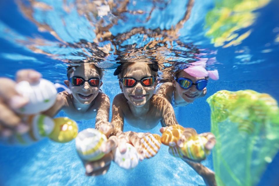 summer easter in swimming pool kids are playing in water and having fun with easter eggsnikon d850