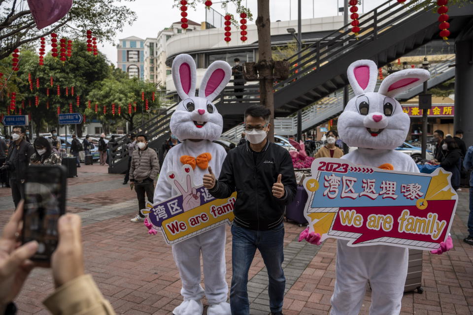 A man posing for a photo with workers dress in rabbit suits welcome visitors outside Futian Port on January 8, 2023 in Shenzhen, China. Hong Kong today resumes quarantine free travel with China, but still requiring travelers to produce a Negative PCR Covid Test Result and register for a crossing quote. (Photo by Vernon Yuen/NurPhoto via Getty Images)