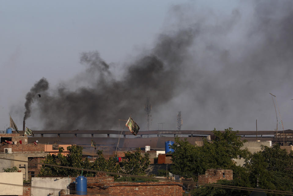 Black smoke is emitted from the chimneys of a factory on the outskirts of Lahore, Pakistan, Friday, April 23, 2021. World leaders from around the globe attended a virtual climate summit to raise global ambition on climate change and talked about their goals for reducing carbon emissions. (AP Photo/K.M. Chaudary)