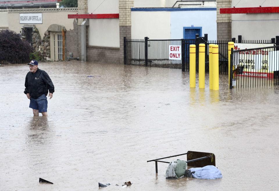 Jack Templeton stands in knee deep water trying to access the storage facility after flooding from heavy rains in Boulder Colorado