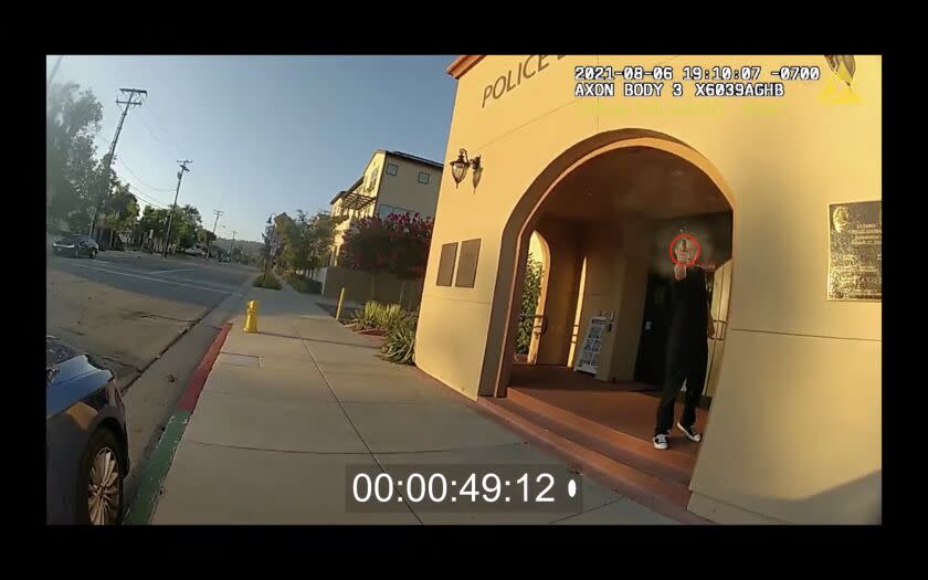 A screenshot from a body camera video of an Aug. 6, 2021 La Habra police shooting shows a suspect pointing a gun at an officer.