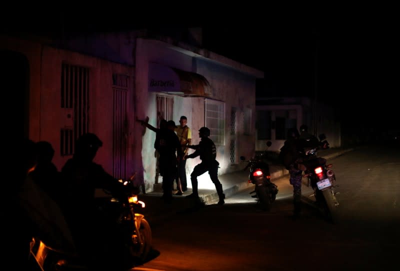 Miembros de las Fuerzas de Acciones Especiales de la Policía Nacional de Venezuela (FAES) interrogan a una persona durante una patrulla nocturna, en Barquisimeto, Venezuela, el 20 de septiembre de 2019