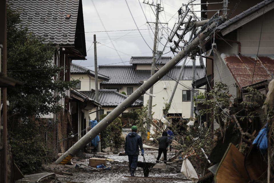 In this Tuesday, Oct. 15, 2019, file photo, residents walk along the mud-covered road in a neighborhood devastated by Typhoon Hagibis, in Nagano, Japan. More victims and more damage have been found in typhoon-hit areas of central and northern Japan, where rescue crews are searching for people still missing. (AP Photo/Jae C. Hong, File)