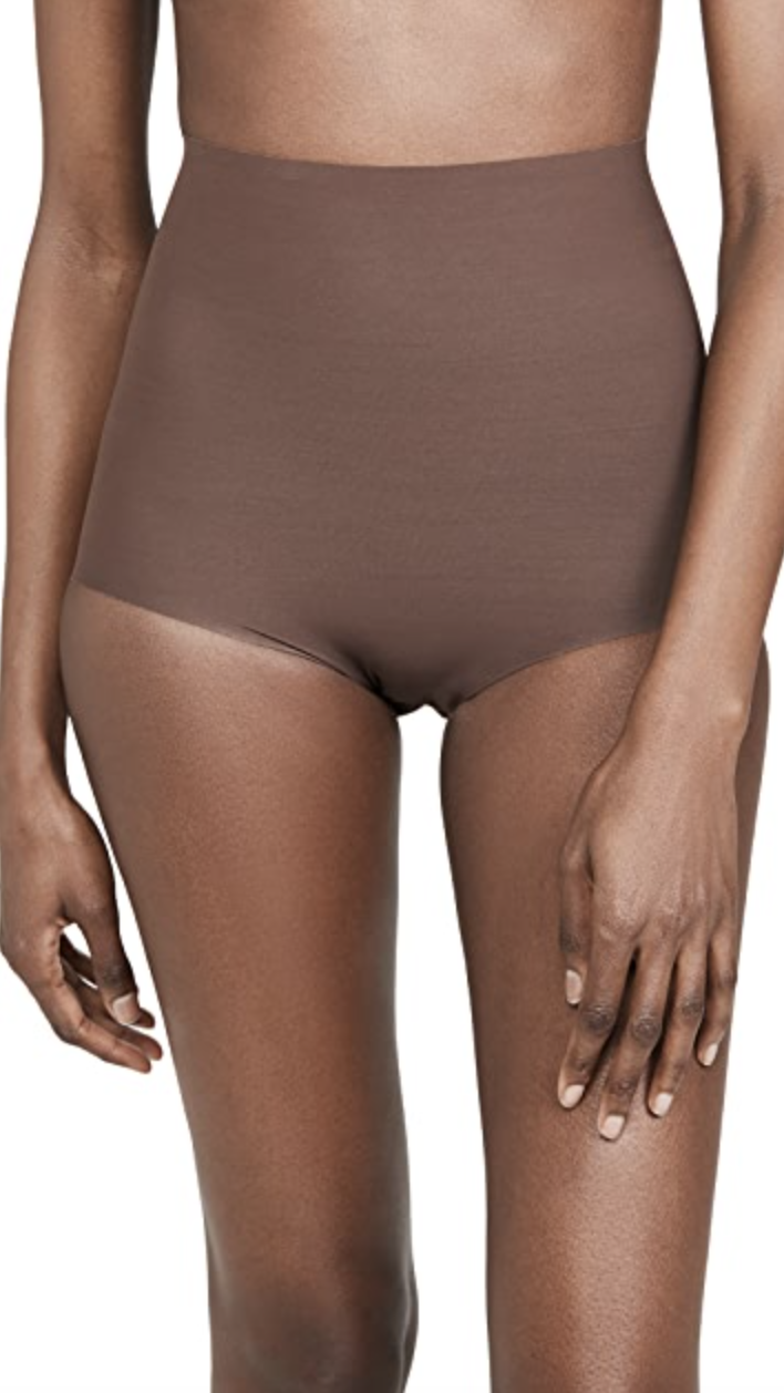 model with upper body cut off wearing brown high waisted control shorts