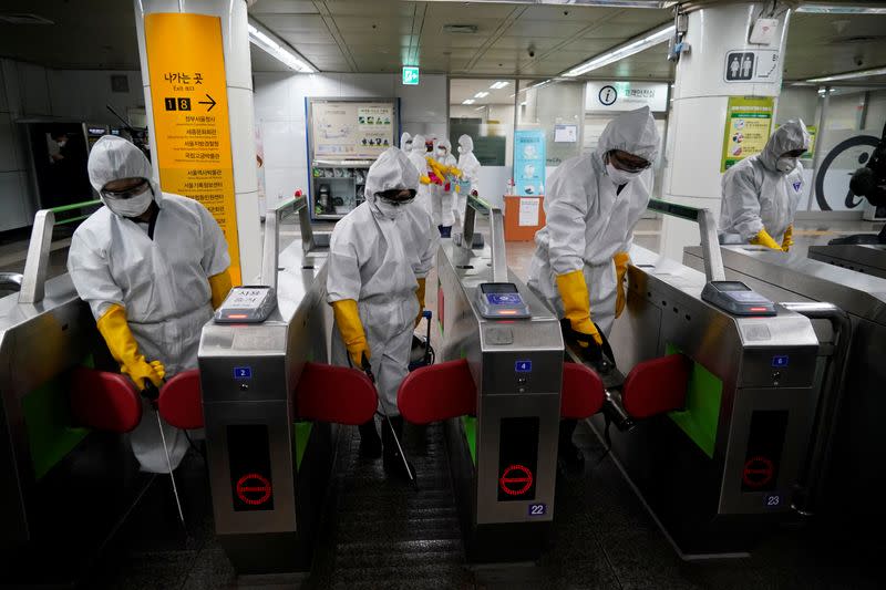 Employees from a disinfection service company sanitize a subway station in Seoul