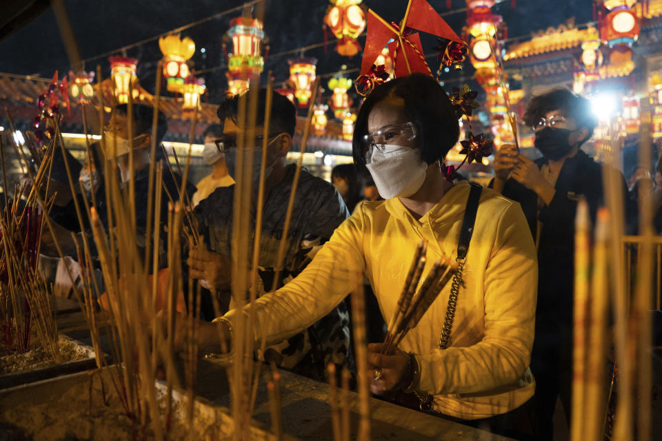 Worshippers wearing face masks burn their first joss sticks as they offer prayer at the Wong Tai Sin Temple, Saturday, Jan. 21, 2023, in Hong Kong, to celebrate the Lunar New Year which marks the Year of the Rabbit in the Chinese zodiac. (AP Photo/Bertha Wang)