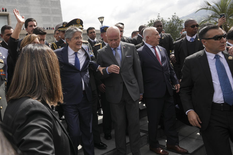 Ecuadorean President Guillermo Lasso, left, leaves the National Assembly after addressing a session where opposition lawmakers seek to try him for embezzlement accusations in Quito, Ecuador, Tuesday, May 16, 2023. (AP Photo/Dolores Ochoa)