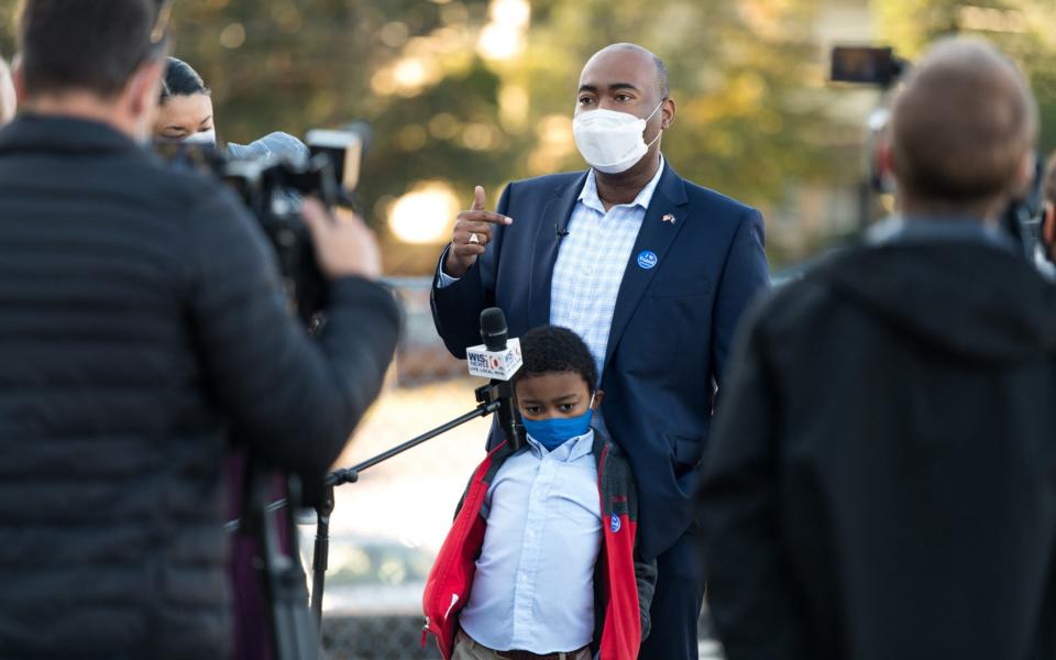 Democratic US senate candidate Jaime Harrison, with his son, William, after casting his vote - Getty