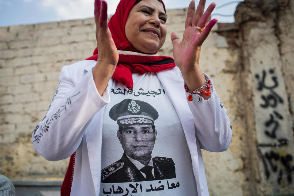 FILE - In this file photo taken Tuesday, Jan. 14, 2014, an Egyptian woman wears a t-shirt with a photo of Egypt's Defense Minister Gen. Abdel-Fattah el-Sissi outside a polling station on the first day of voting in the country's constitutional referendum in Cairo, Egypt. While last week's constitutional referendum approved the draft charter, the low turnout - less than 39 percent - has put on display the country's enduring divisions six months after the ouster of Islamist President Mohammed Morsi and nearly three years after autocrat Hosni Mubarak was overthrown. (AP Photo/Eman Helal, File)