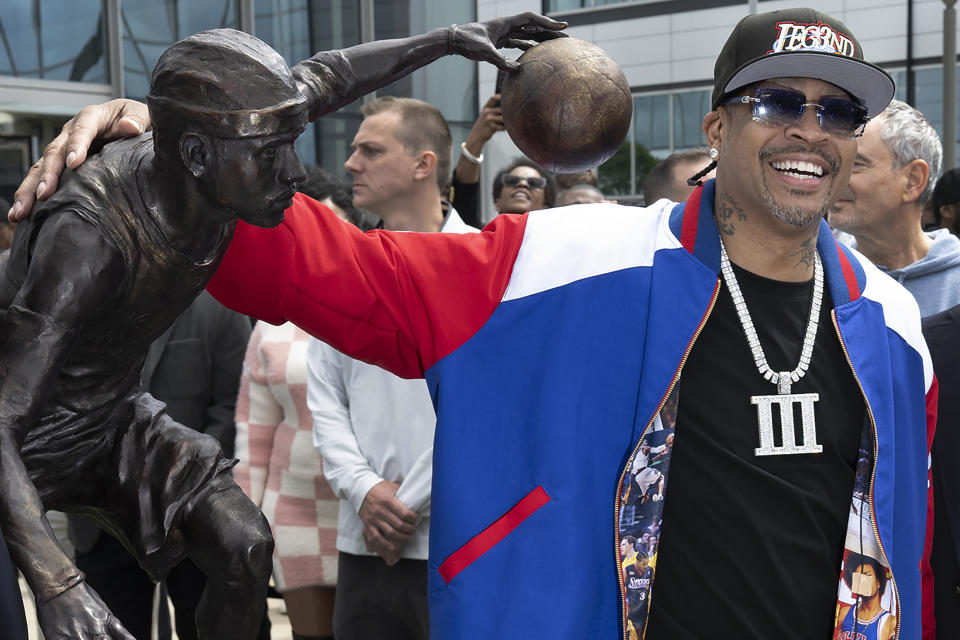 Former Philadelphia 76ers NBA basketball player Allen Iverson poses for photos next to his statue at the teams training center in Camden, N.J., Friday, April 12, 2024 (Jose F. Moreno/The Philadelphia Inquirer via AP)