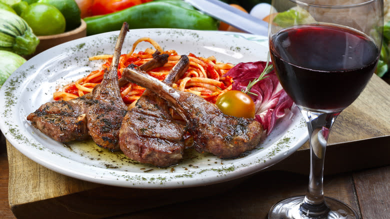 Lamb chops beside a glass of red wine
