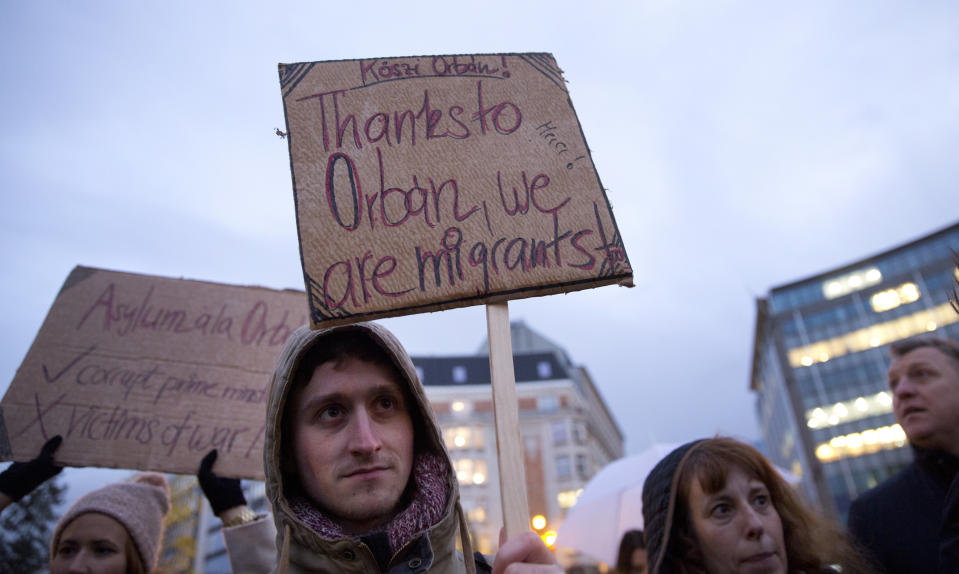 FILE - In this Jan. 8, 2019 file photo, a protestor holds a placard which reads, 'Thanks to Orban we are migrants too', during a demonstration outside EU headquarters in Brussels. Battle lines are drawn between anti-EU populist forces and traditional parties at the beginning of a three-month election campaign that could turn into a tipping point in postwar European history. The May 2019 EU elections has already produced unprecedented abrasive campaigning. (AP Photo/Virginia Mayo, File)