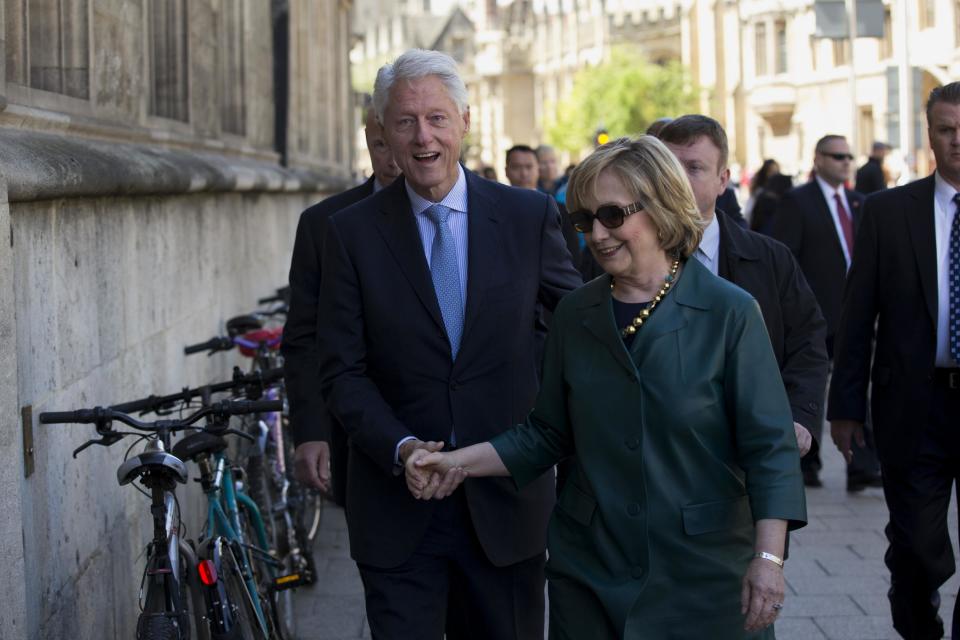 Former U.S. President Bill Clinton, left, and his wife former Secretary of State Hillary Rodham Clinton walk into a building entrance after they attended their daughter Chelsea's Oxford University graduation ceremony held at the Sheldonian Theatre in Oxford, England, Saturday, May 10, 2014. Chelsea Clinton received her doctorate degree in international relations on Saturday from the prestigious British university. Her father was a Rhodes scholar at Oxford from 1968 to 1970. The graduation ceremony comes as her mother is considering a potential 2016 presidential campaign. (AP Photo/Matt Dunham)