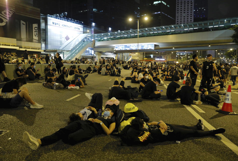 Protesters rest on the streets as they continue a protest overnight near the Legislative Council into the early hours of Monday, June 17, 2019 in Hong Kong. Hong Kong citizens marched for hours Sunday in a massive protest that drew a late-in-the-day apology from the city's top leader for her handling of legislation that has stoked fears of expanding control from Beijing in this former British colony. (AP Photo/Vincent Yu)