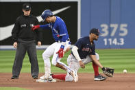 Toronto Blue Jays' Cavan Biggio, center, is safe at second ahead of a tag by Boston Red Sox shortstop Xander Bogaerts, right, after hitting a double in the fourth inning of a baseball game in Toronto, Monday, June 27, 2022. (Jon Blacker/The Canadian Press via AP)