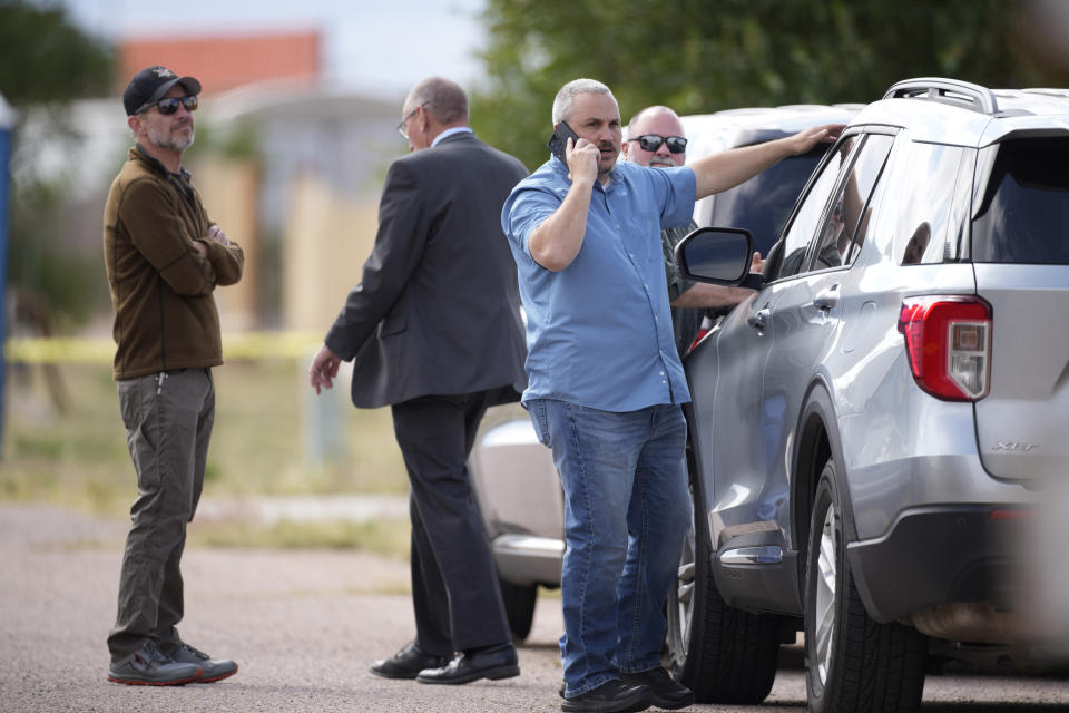 Authorities wait outside a closed funeral home where 115 bodies have been stored, Friday, Oct. 6, 2023, in Penrose, Colo. Authorities are investigating the improper storage of human remains at the southern Colorado funeral home that performs "green" burials without embalming chemicals or metal caskets. (AP Photo/David Zalubowski)