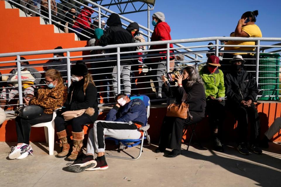 People wait in line to receive a $250 grocery gift card available to Miami residents experiencing hardship and food insecurity due to COVID-19, Tuesday, Dec. 8, 2020, in Miami. (AP Photo/Lynne Sladky)