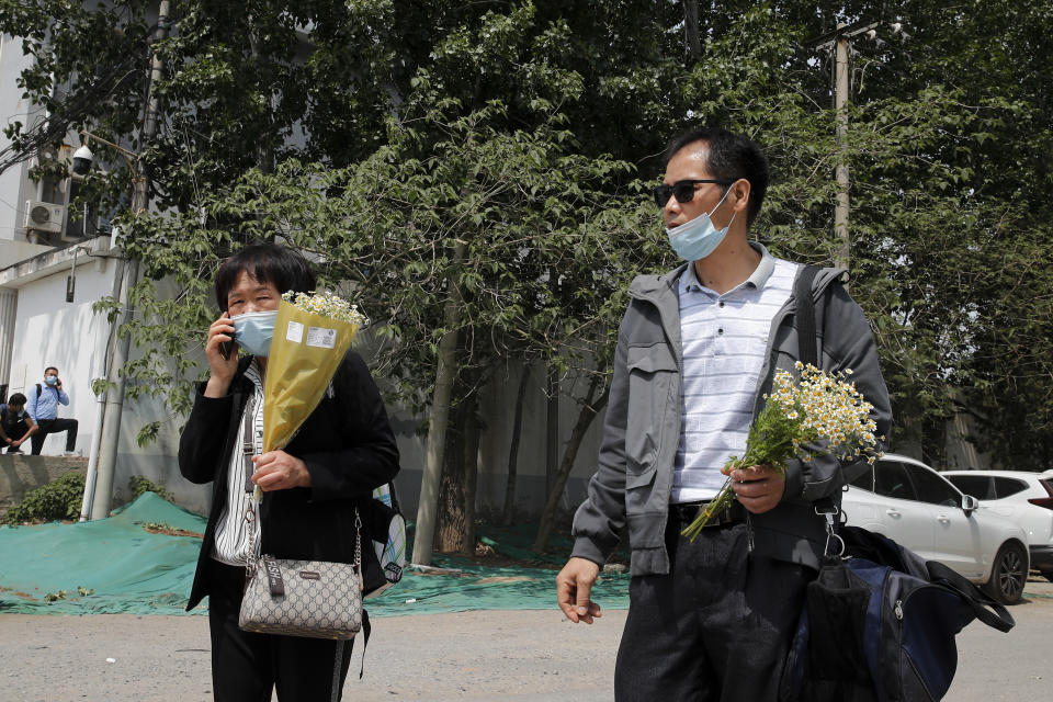 Wei Xiuwen, left, mother of Chen Mei, and Cai Jianli, father of Cai Wei, leave a courthouse after attending their children's court cases in Beijing, Tuesday, May 11, 2021. Two amateur computer coders taken by police from their Beijing homes last year were standing trial Tuesday in a case that illustrates the Chinese government's growing online censorship and heightened sensitivity to any deviation from the official narrative on its COVID-19 response. (AP Photo/Andy Wong)