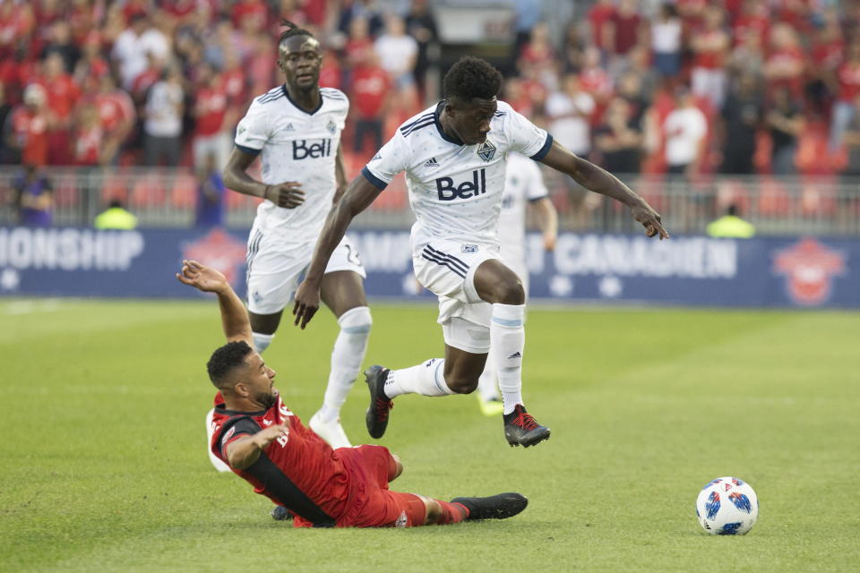 Vancouver Whitecaps forward Alphonso Davies, right, leaps over the challenge by Toronto FC defender Justin Morrow during the first half in the second leg of the Canadian soccer championship final, Wednesday, Aug. 15, 2018, in Toronto. (Chris Young/The Canadian Press via AP)