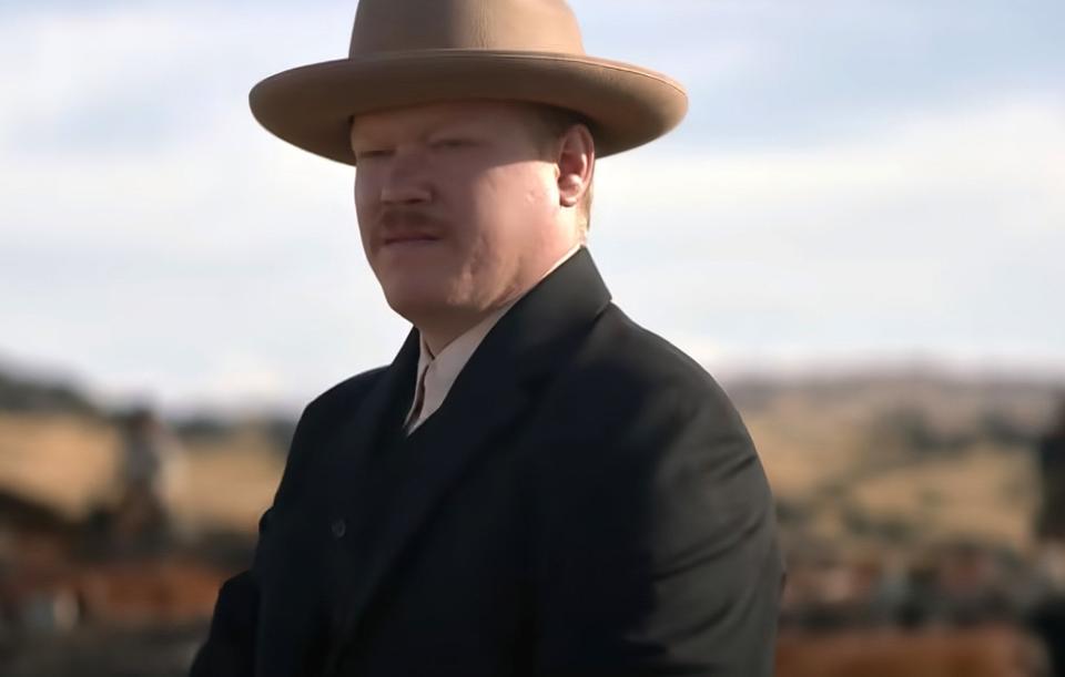 Jesse Plemons stands in a field