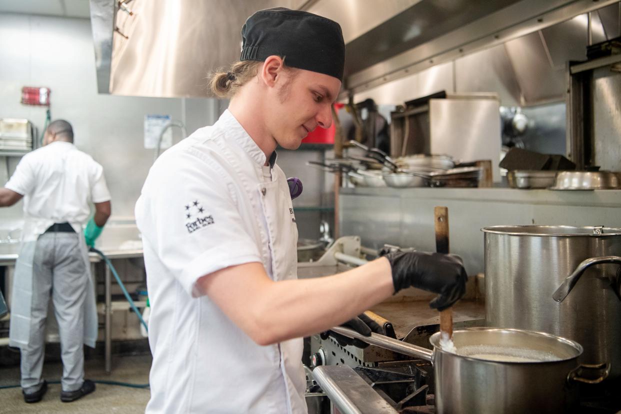 Banquet Demi Chef Roman Nourse stirs a pot as he makes burrata in the kitchen at The Inn on Biltmore Estate, July 9, 2024.