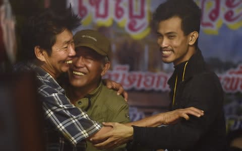 Family members celebrate while camping out near Than Luang cave  - Credit: AFP