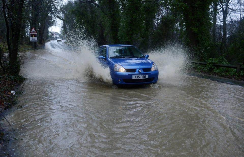 A car drives through flood water (PA) (PA Archive)