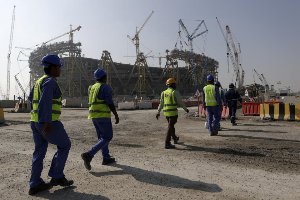 FILE - Workers walk to the Lusail Stadium, one of the 2022 World Cup stadiums, in Lusail, Qatar, Friday, Dec. 20, 2019. The eight stadiums for the World Cup, all within a 30-mile radius of Doha, are now largely complete. (AP Photo/Hassan Ammar, File)