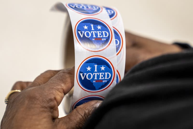 A poll worker holds a roll of “I Voted” stickers to hand out to voters on the morning of the South Carolina Republican primary at Cayce United Methodist Church in Cayce, S.C., Saturday, Feb. 24, 2024. (AP Photo/Andrew Harnik)