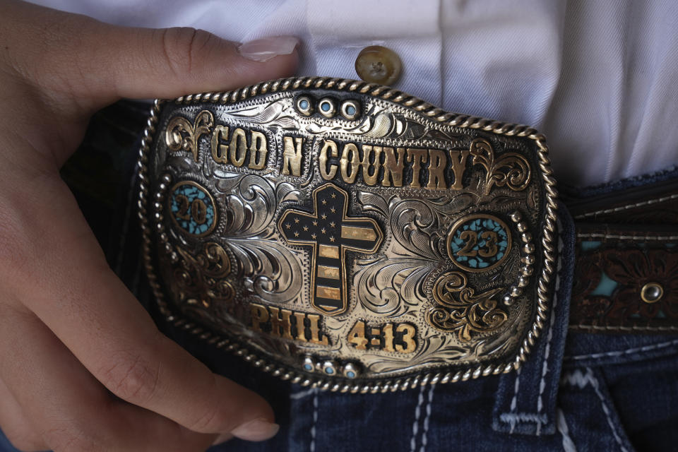 Bull rider Najiah Knight shows her belt buckle after an advertising photo shoot in Fort Worth, Texas, Wednesday, Oct. 4, 2023. Najiah, a high school junior from small-town Oregon, is on a yearslong quest to become the first woman to compete at the top level of the Professional Bull Riders tour. (AP Photo/LM Otero)