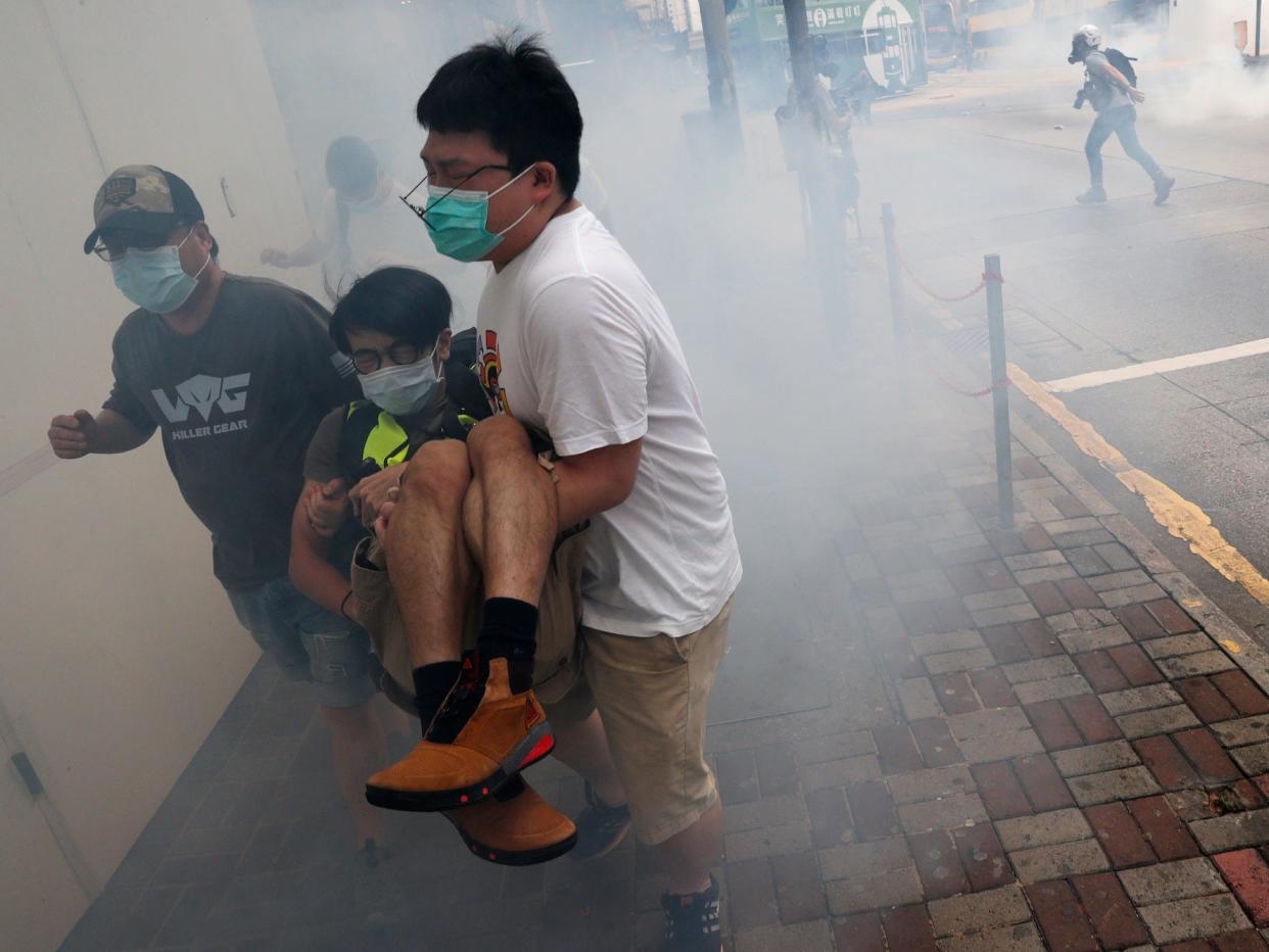 Anti-government protesters flee from tear gas during a march against Beijing’s plans to impose national security legislation in Hong Kong, China 2020.