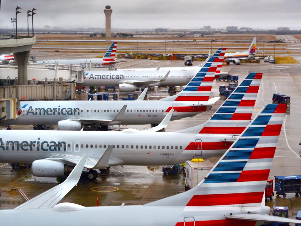 A number of American Airlines planes docked at an airport.