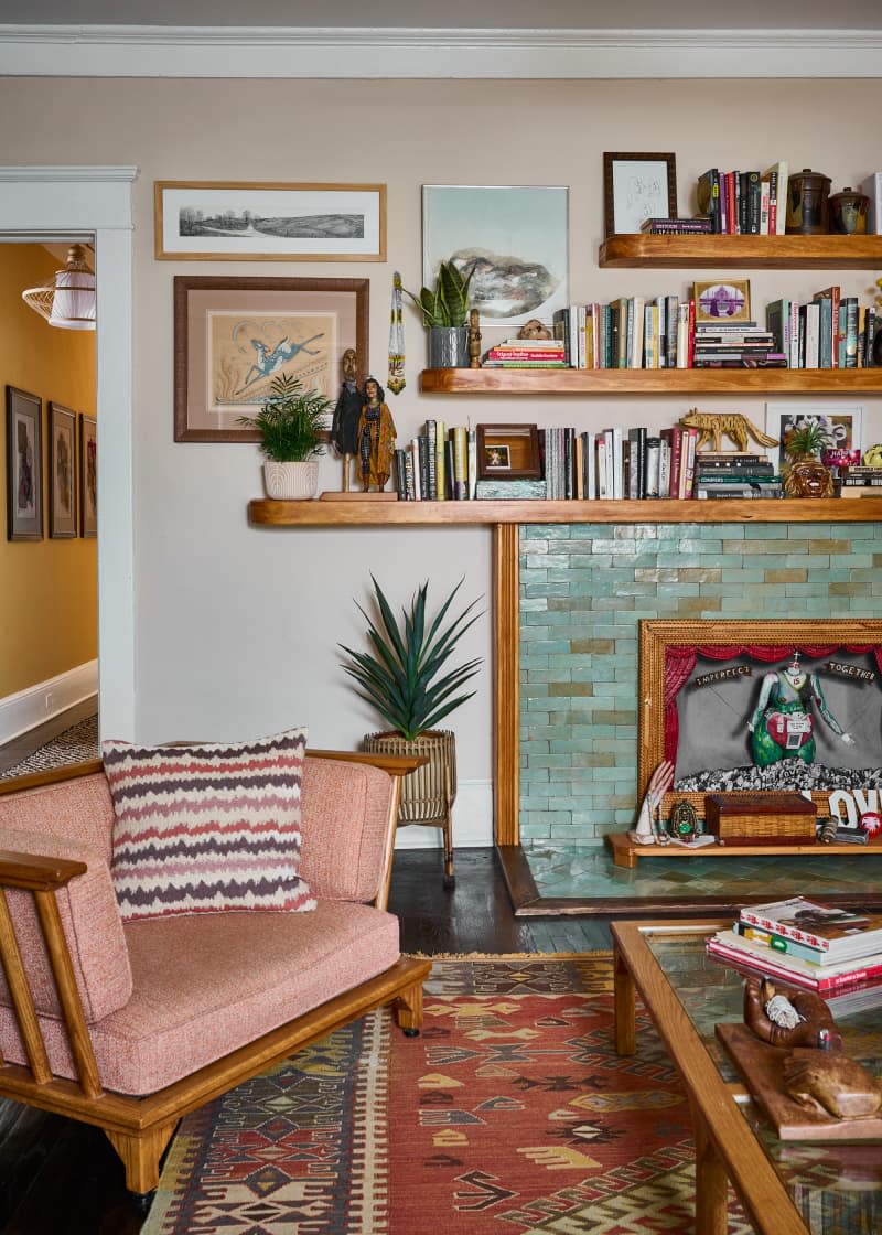 Bookshelves above green tiled fireplace.