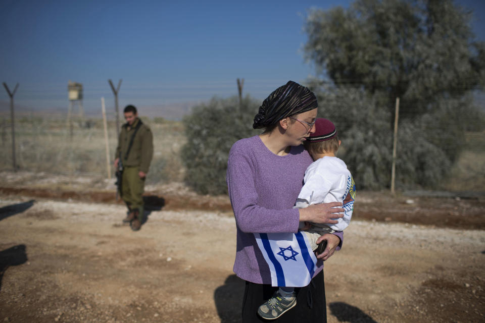 Israeli settlers gather during a visit of Israeli politicians at Gitit settlement in the West Bank’s Jordan Valley, Thursday, Jan. 2, 2014. Hawkish Israeli politicians visited a settlement in the West Bank’s Jordan Valley on Thursday, saying their trip was a message to visiting U.S. Secretary of State John Kerry that Israel will never relinquish the strategic area. Kerry is meeting with the Israeli and Palestinian leaders over the next few days, and the fate of the Jordan Valley is expected to be raised in those talks. (AP Photo/Oded Balilty)