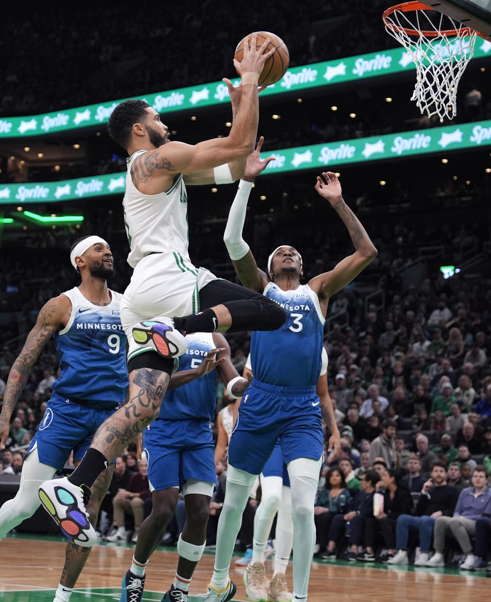 Boston Celtics forward Jayson Tatum (0) drives to the basket against Minnesota Timberwolves forward Jaden McDaniels (3) during the first half of an NBA basketball game Wednesday, Jan. 10, 2024, in Boston. (AP Photo/Charles Krupa)