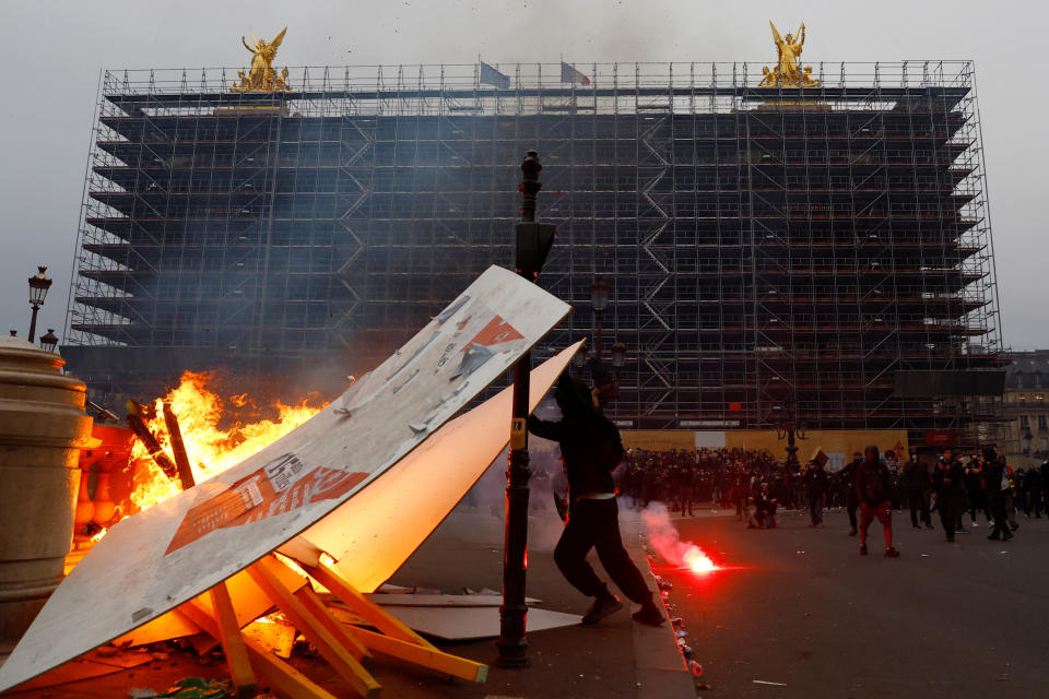 Protesters set objects on fire in front of the Opera Garnier amid clashes during a demonstration as part of the ninth day of nationwide strikes and protests against French government's pension reform, in Paris, France, March 23, 2023.  REUTERS/Gonzalo Fuentes