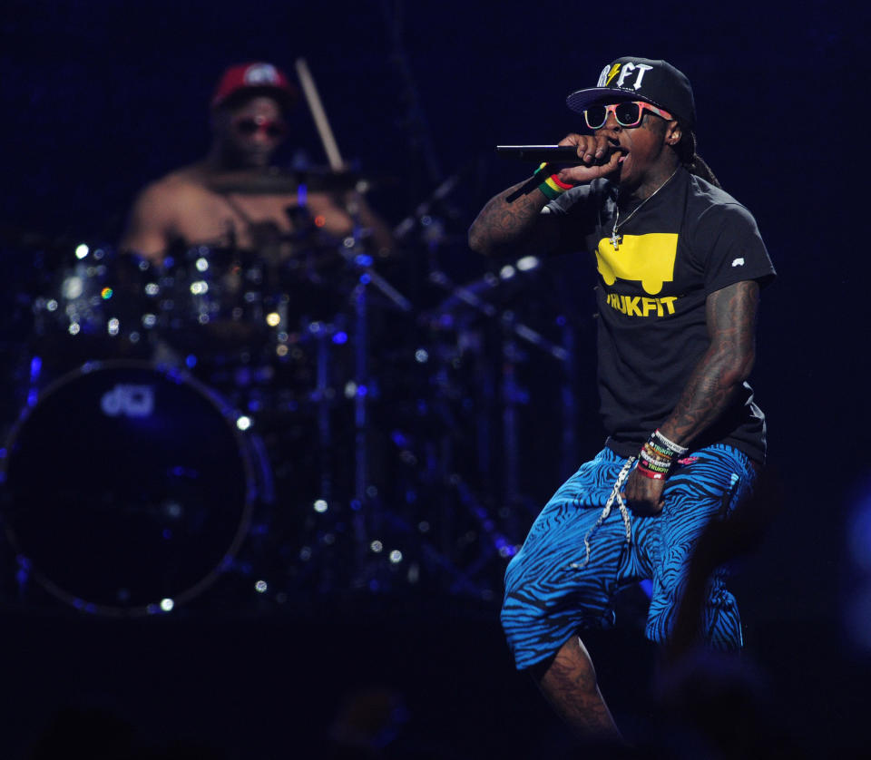 FILE - In this Sept. 21, 2012 file photo, Lil Wayne performs at the iHeart Radio Music Festival at the MGM Grand Arena in Las Vegas. Lil Wayne and Rick Ross, two of the most celebrated and successful artists in rap today, recently lost major endorsements after protests forced high profile corporations to drop the rap stars. Both artists rapped lyrics deemed vulgar and over-the-top; one referring to rape, the other about the beating of Emmett Till, on songs where they were the featured acts. (Photo by Eric Reed/Invision/AP, File)