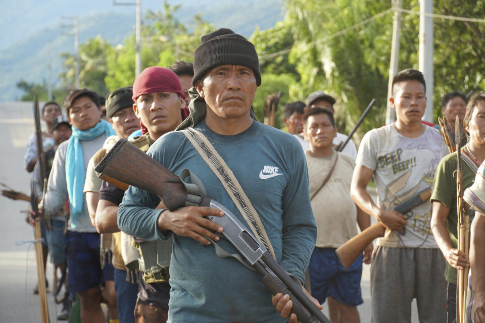 Hombres indígenas Ashaninka, armados con escopetas y arcos y flechas, se forman para bloquear una carretera en protesta por la muerte del líder Ashaninka Santiago Contoricon, de 57 años, en Puerto Ocopa, Perú, el viernes 14 de abril de 2023. Contoricón, que luchó contra el tráfico de drogas, es la víctima número 22 entre líderes indígenas peruanos asesinados en los últimos tres años. (AP Foto/Franklin Briceño)