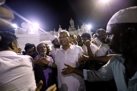 Sri Lanka's former wartime defense secretary and presidential candidate Rajapaksa shares a moment with Muslims during his visit at Ketchimale mosque in Beruwala