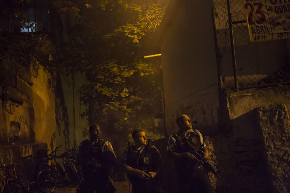 Police officers of the Pacifying Police Unit, patrol during clashes at the Pavao Pavaozinho slum in Rio de Janeiro, Brazil, Tuesday, April 22, 2014. Intense exchanges of gunfire, numerous blazes set alit and a shower of homemade explosives and glass bottles onto a busy avenue in Rio de Janeiro’s main tourist zone erupted Tuesday night after the death of a popular young shantytown resident. (AP Photo/Felipe Dana)