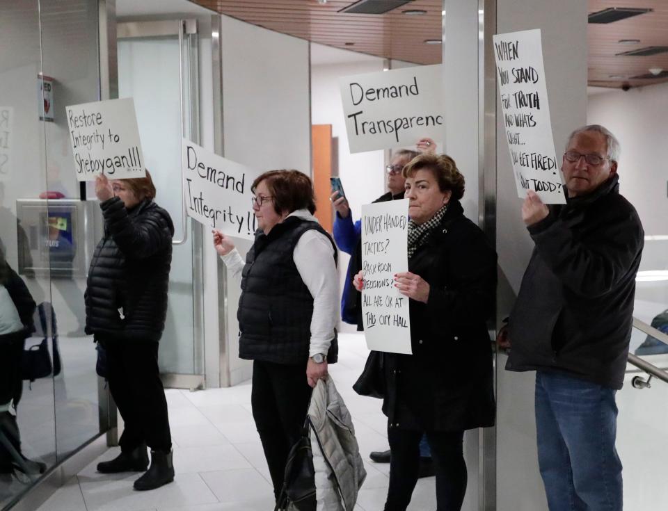 FILE - People hold signs during a meeting at Sheboygan City Hall on Jan. 9, 2022.