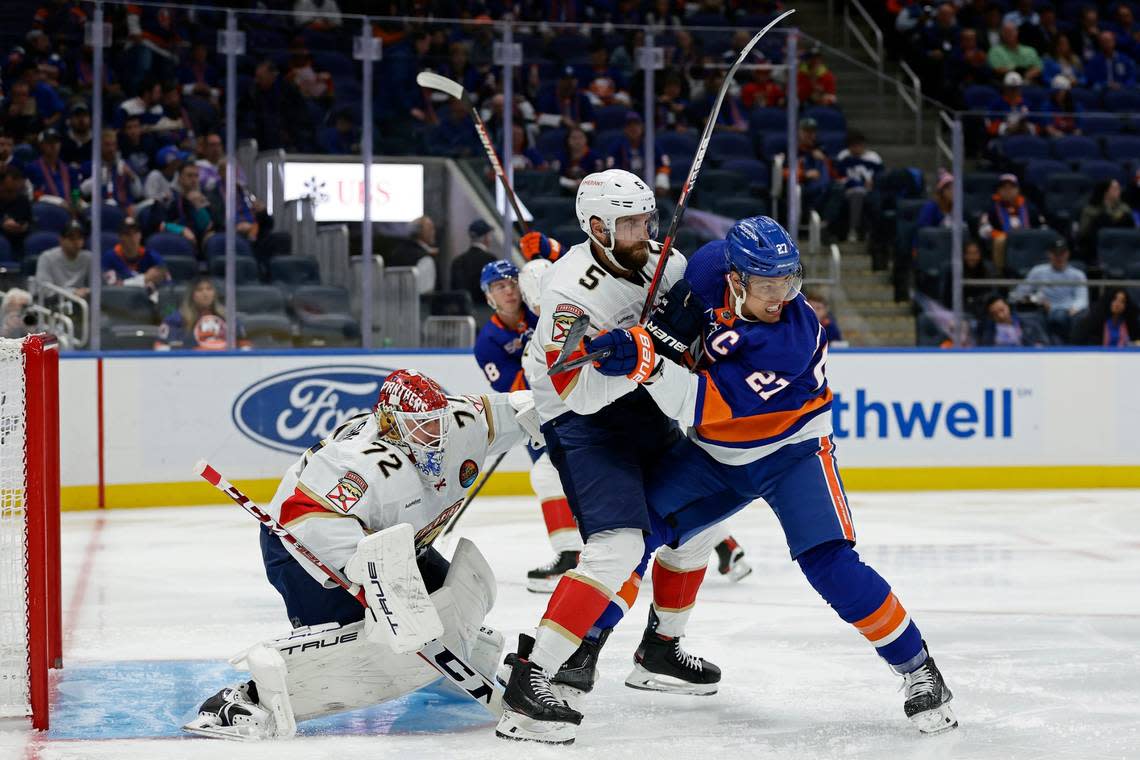 New York Islanders left wing Anders Lee (27) battles for position with Florida Panthers defenseman Aaron Ekblad (5) in front of Sergei Bobrovsky (72) in the second period of an NHL hockey game Thursday, Oct. 13, 2022, in Elmont, N.Y. (AP Photo/Adam Hunger)