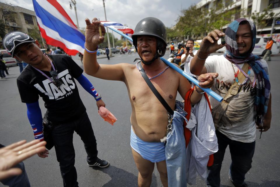 Anti-government protesters show off a rubber bullet and a bullet cartridge during clashes with police near the Government House in Bangkok