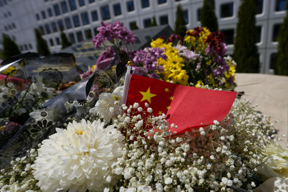 A Chinese flag is placed near flowers on a monument at the site of a former Chinese Embassy in Belgrade, Serbia, Monday, April 29, 2024. During NATO bombing campaign, in 1999, jets bombed the Chinese Embassy in Belgrade, killing three people and 20 injured. (AP Photo/Darko Vojinovic)