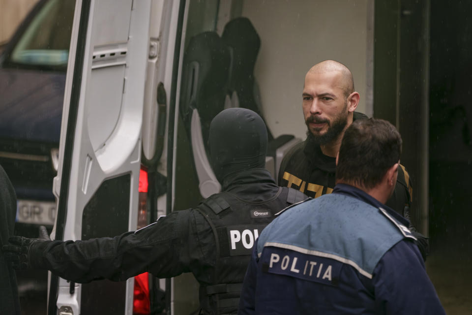 Police officers escort Andrew Tate, center, to the Court of Appeal in Bucharest, Romania, Tuesday, March 12, 2024. Online influencer Andrew Tate was detained in Romania and handed an arrest warrant issued by British authorities, his spokesperson said Tuesday. (AP Photo/Andreea Alexandru)