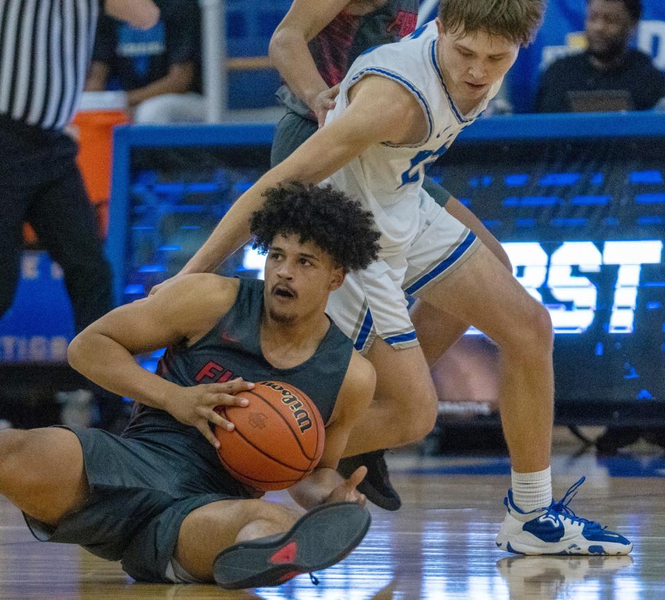 Fishers High School's Keenan Garner (23) comes up with a loose ball as he works against Hamilton Southeastern High School's Joe Karwowski (23) at Carmel High School, Tuesday, Feb. 28, 2023, during the Fishers boys’ sectional win over HSE, 68-49. 