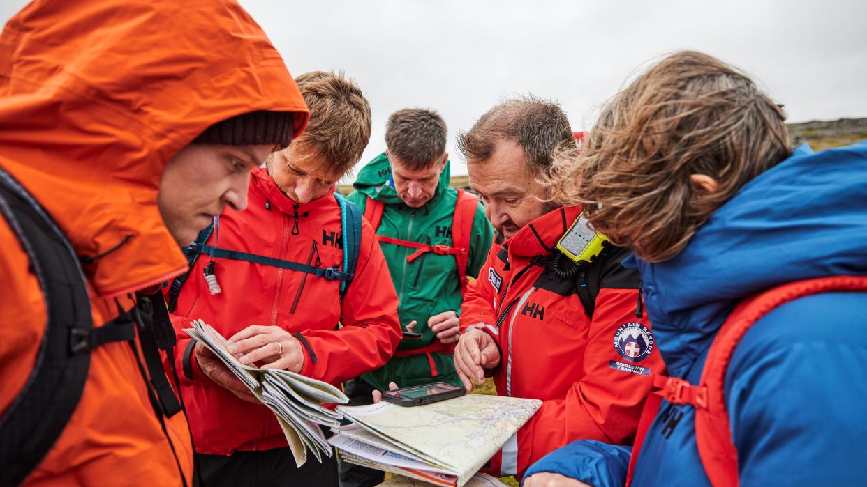  Why learn navigation: A group of hikers examine a map. 