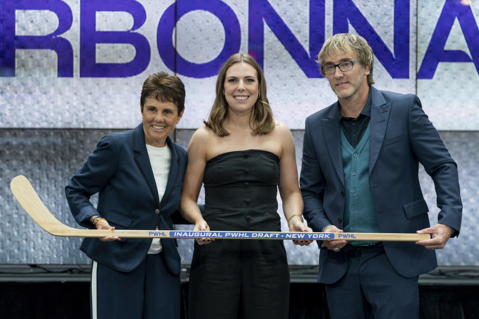 FILE - Jaime Bourbonnais, center, from the PWHPA, poses with New York general manager Pascal Daoust, right, and former tennis player Ilana Kloss, left, after being selected ninth overall by New York during the second round of the inaugural Professional Women's Hockey League draft in Toronto, Monday, Sept. 18, 2023. The newly established Professional Women's Hockey League is on the cusp of taking the next step in preparing to open play in January with its six teams opening training camp this week. (Spencer Colby/The Canadian Press via AP, File)