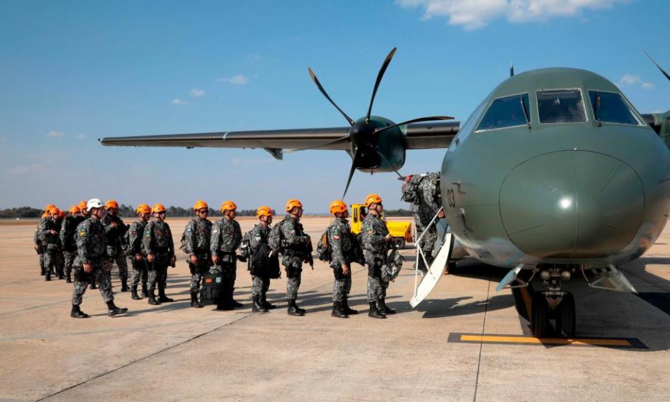 National Force military firefighters stand in line to board a plane to help fight fires in the Amazon