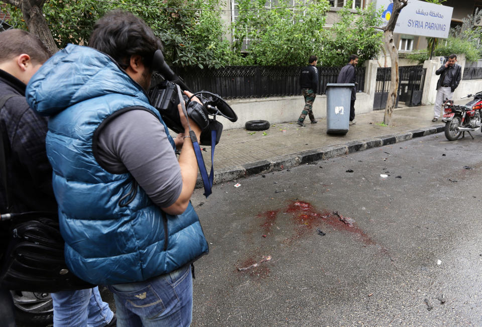 Journalists take footage at the scene of a suicide attack  in central Damascus on December 3, 2013. (LOUAI BESHARA/AFP/Getty Images)